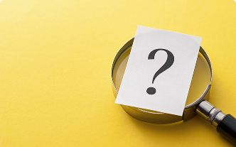 Magnifying glass with a question mark sitting on top of it on a yellow background