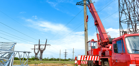 Red Truck in a field with power lines